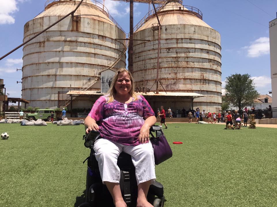 Terri in front of two huge silos.